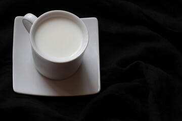 Home cozy composition. Cup of milk on black background. Fall background. Flat lay, top view, copy space