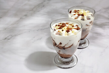 Two glasses with ice cream on marble background. Summer background