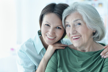 Portrait of senior woman with daughter at home