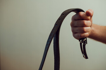 Man's hand with leather belt. Domestic violence and child abuse. Spanking concept. Problems and criminal in family. - obrazy, fototapety, plakaty