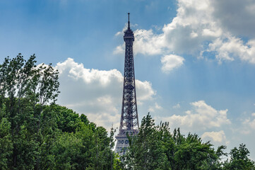 Fototapeta na wymiar It's The Eiffel tower over the trees