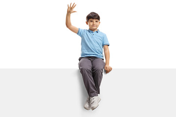 Fototapeta na wymiar Boy sitting on a blank panel and waving