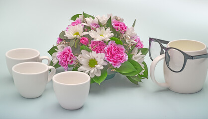 Flowers for dad. Celebration background for happy father's day. Creative breakfast with funny face made from a cups of coffee and glasses.