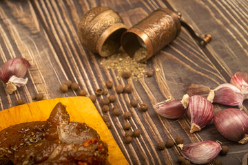 Marinated meat on a cutting Board, garlic, allspice, spices. Close up.