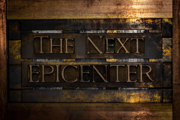 The Next Epicenter text formed with real authentic typeset letters on vintage textured silver grunge copper and gold background