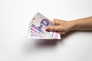 Female hand holds a thousand hryvnia. Ukrainian currency with woman's hand against a white...