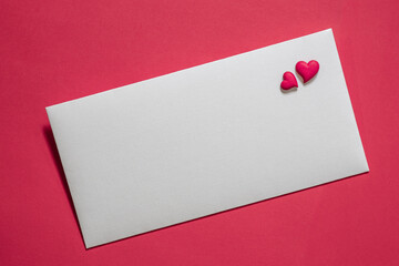 white envelope on a pink background, two red hearts on a letter, blank for design, greeting card, free space for text