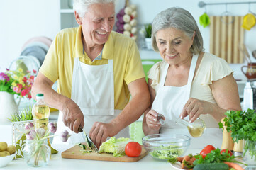Portrait of senior couple cooking together at kitchen
