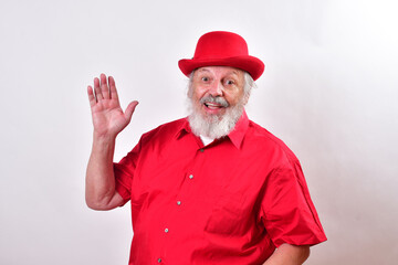 Cheerful gentleman giving the open hand greeting gesture..Happy old man with a red bowler hat...