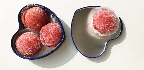Sweet red cookies in a blue heart-shaped box on the table. Isolated cookies, the view from the top.