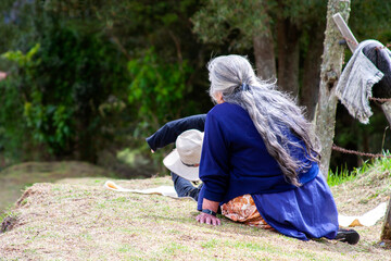 Mujer sentada sobre la hierba contemplando la naturaleza