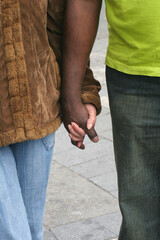 Pareja interracial caminando por la calle cogidos de la mano
