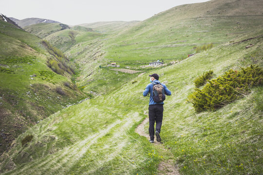 Males Person With Face Mask Is Walking Don The Path Looking To Green Nature Around. Post Pandemic Travel And Self Distance In Nature. Kazbegi National Park. Georgia.2020