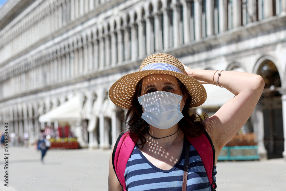 Wall mural woman with surgical mask and straw hat on tourist visit in the i