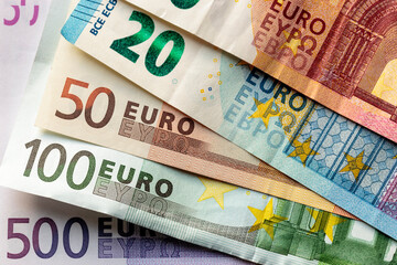 Obraz premium Obverse side of overlapped Euro Zone banknotes of 5, 10, 20, 50, 100, and 500 Euro denominations. Horizontal macro close-up view.