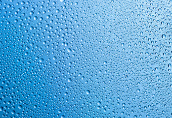 Background of water drops on gradient blue surface.