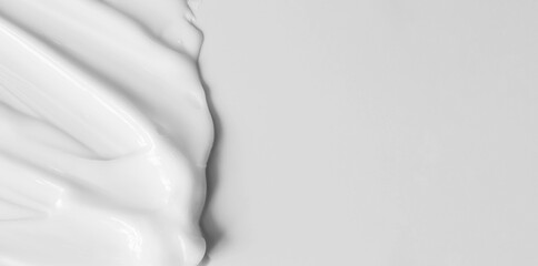 Close-up cream moisturiser smear smudge wavy texture on white background with copy space horizontal...