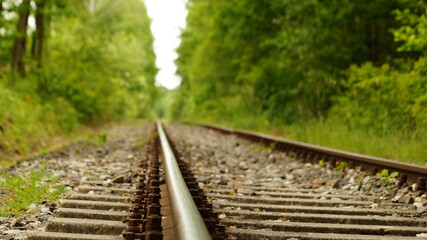 Widok z poziomu torów kolejowych z rozmytym tłem. Nostalgia podróży lub niekończącej się perspektywy.