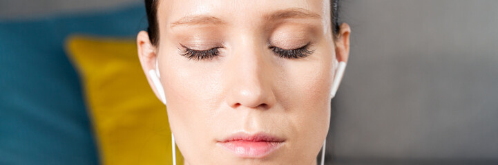 Close up portrait of attractive relaxed young woman meditating at home. Girl with eyes closed