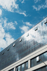 modern corporate building with clouds reflecting in the glass