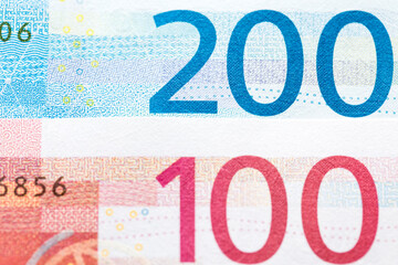 Reverse sides of of the 100 and 200-krone notes overlapped
