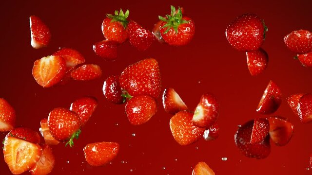 Super slow motion of falling strawberries with water splashes. Filmed on high speed cinema camera, 1000fps