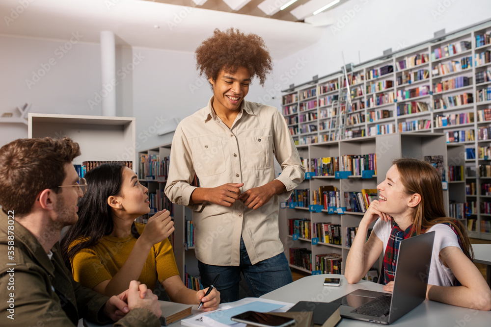 Poster university students are studying in a library together. concept of teamwork and preparation