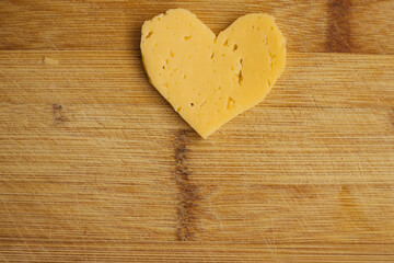 Cheese in the shape of a heart on a wooden Board. Grated cheese in the shape of a heart.