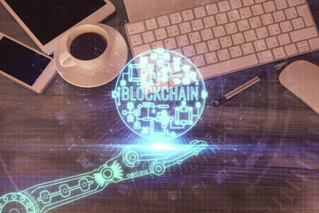 Double exposure of blockchain theme hologram over table with phone. Top view. Crypto technology concept.