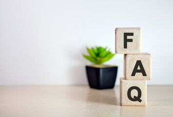 FAQ - text on wooden cubes, on wooden flowers background
