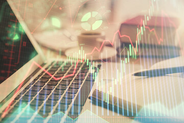 Double exposure of financial chart drawing and desktop with coffee and items on table background. Concept of forex market trading