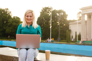woman searching job with a laptop in an urban park in summer