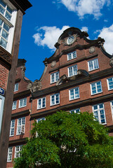 Fototapeta premium Beautiful dark brown brick building with white windows. Typical architecture of Hamburg, Germany on a sunny, clear day.
