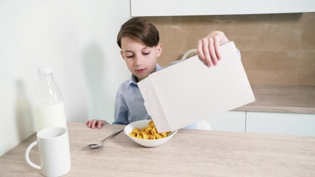 Beautiful baby brunette prepares a breakfast of cereal and milk.