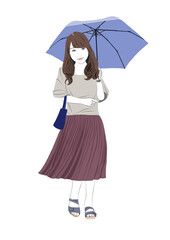 ブルーの傘をさして街を歩く女性