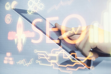 Multi exposure of man's hands holding and using a digital device and seo drawing. search...