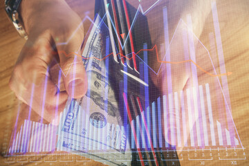 Multi exposure of forex graph drawing hologram and USA dollars bills and man hands. Technical Analysis concept.