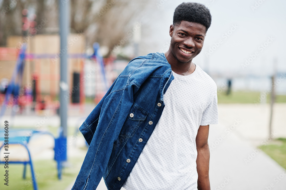 Wall mural young millennial african boy in city. happy black man in jeans jacket. generation z concept.