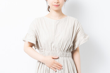 お腹に手を当てる若い女性