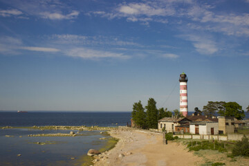 old lighthouse and the shore of the bay with stones aerial view. The lighthouse guards the ships from wreck