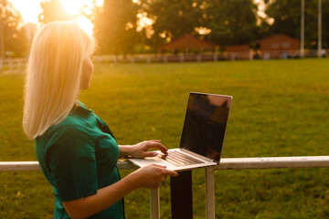woman searching job with a laptop in an urban park in summer