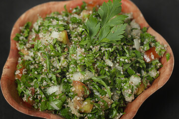 Tabbouleh: arabic salad in wooden bowl
