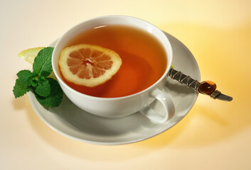 A cup of tea with lemon in a white cup