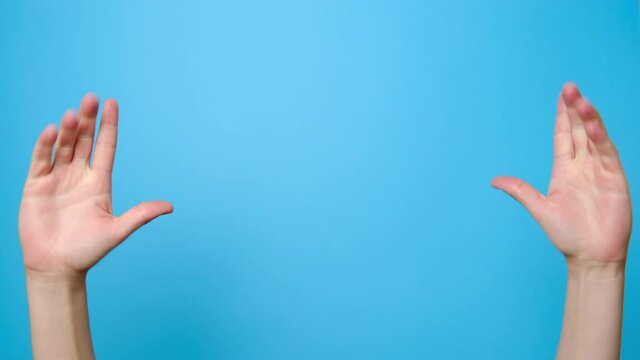 Close up of female hands gesture of showing small size with two fingers, isolated over blue studio background with copy space for advertisement. Advertising area, mock up.
