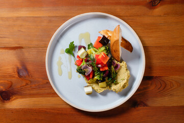 Hummus with croutons and vegetables. Healthy vegan dish.