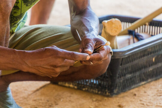 TAMAN NEGARA, MALAYSIA - MARCH 17, 2018: Indigenous man making darts for a blowpipe in his village in Taman Negara national park, Malaysia