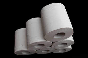 Rolls of toilet paper stacked. Isolated on black background. Horizontal shot. Close-up. Top view.