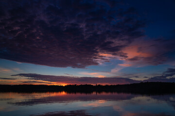 Reflection of textured sunset clouds on lake
