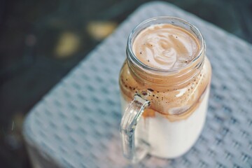 Close up of a glass of dalgona coffee with nature background.