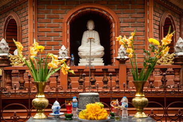 White buddhist statue with flowers in Tran Quoc Pagoda Hanoi, Vietnam